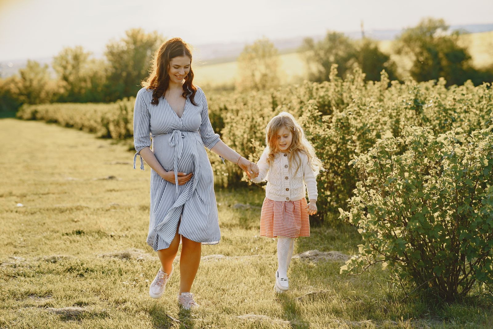 A parent and child walking together outdoors in the El Paso afternoon light